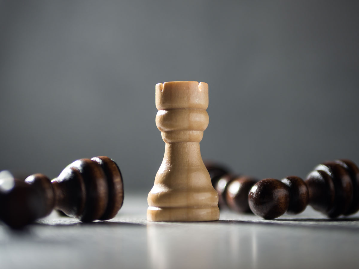 Turm beim Schach steht neben liegenden Bauern als Symbol für Resilienz